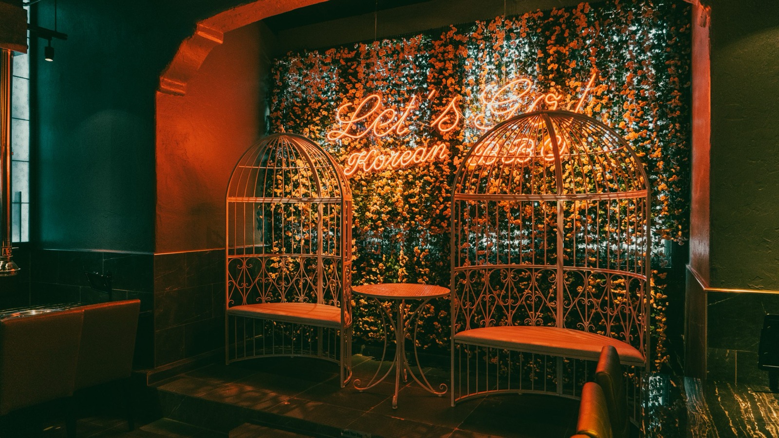 Neon flower wall and decorative birdcage seating at Gaja Korean BBQ Oceanside