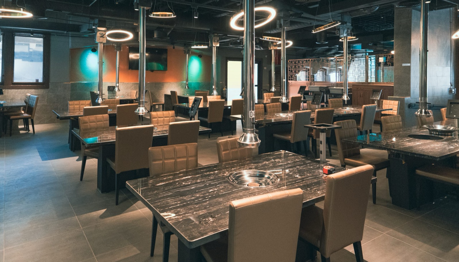 Spacious dining room with grill tables and modern lighting at Gaja Korean BBQ